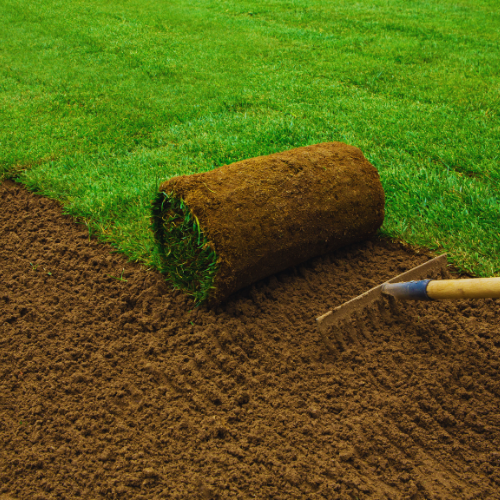 A roll of grass next to a field.
